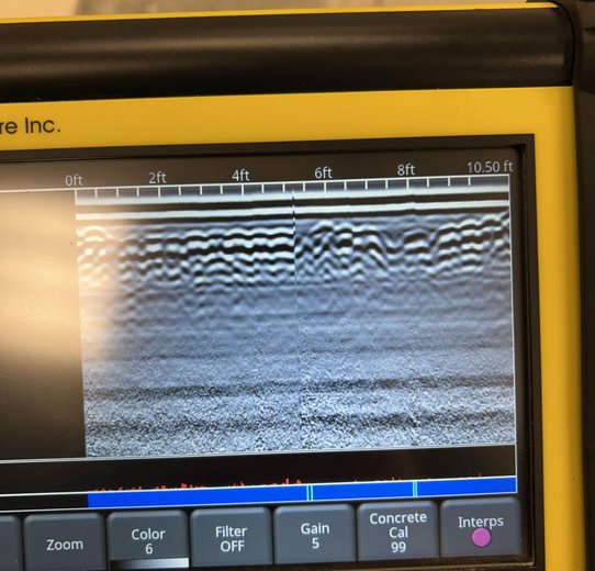A portable device with a screen visualizing a waveform for monitoring concrete