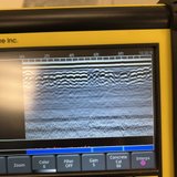 A portable device with a screen visualizing a waveform for monitoring concrete